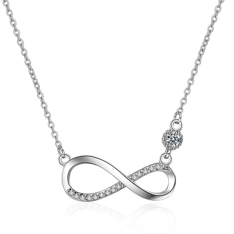 Silver infinity necklace with a small round pendant on a white background