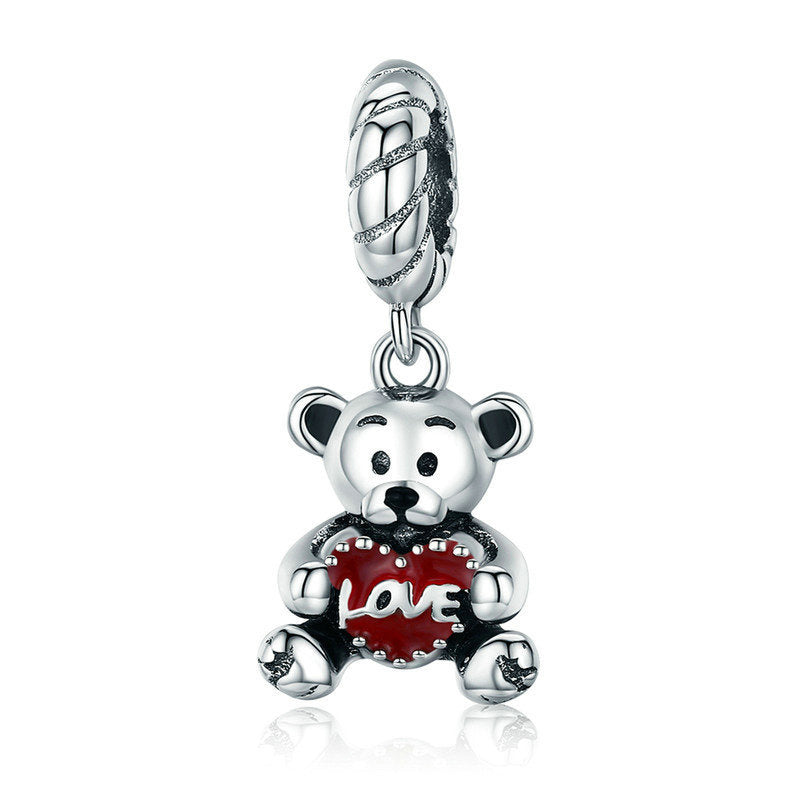 Silver charm shaped like a teddy bear holding a red heart with 'love' on a white background