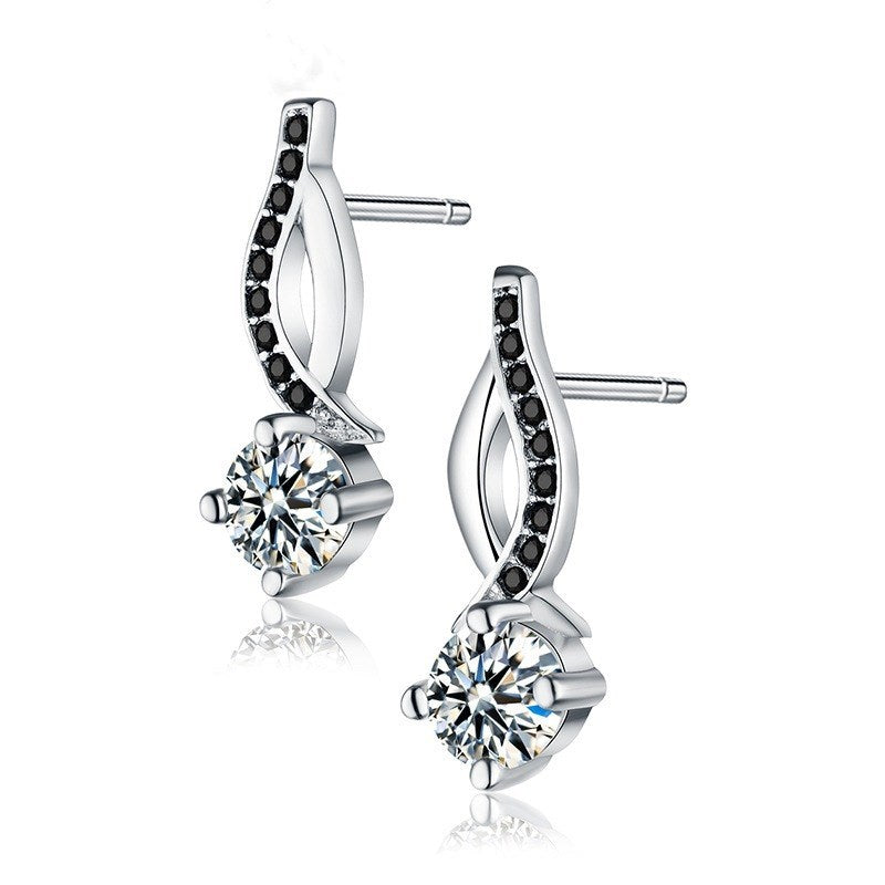 Silver earrings with black and clear gemstones on a white background