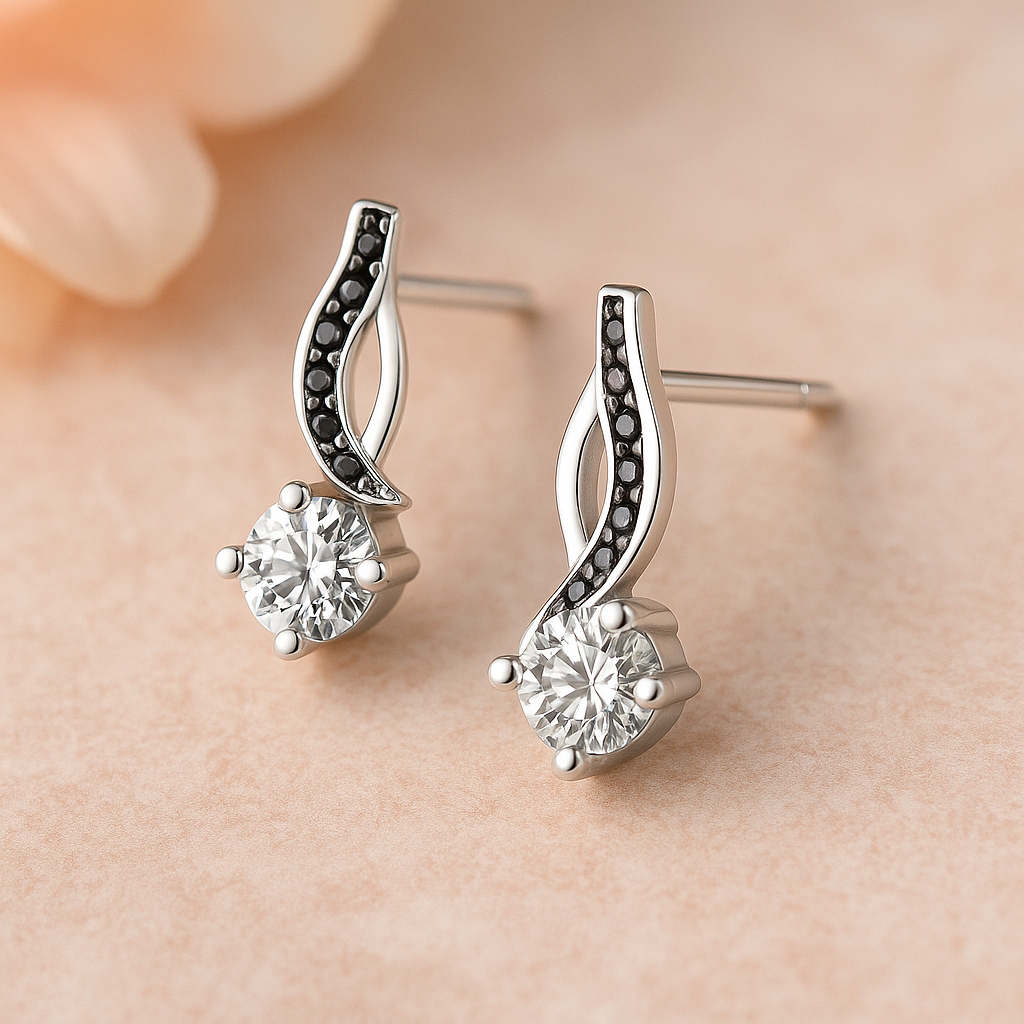 Silver earrings with black and clear gemstones on a beige background