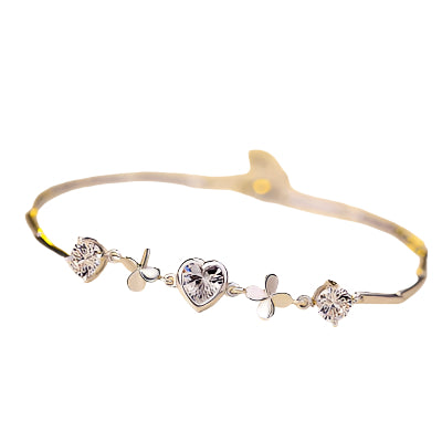 Gold bracelet with heart-shaped charms and crystals on a white background