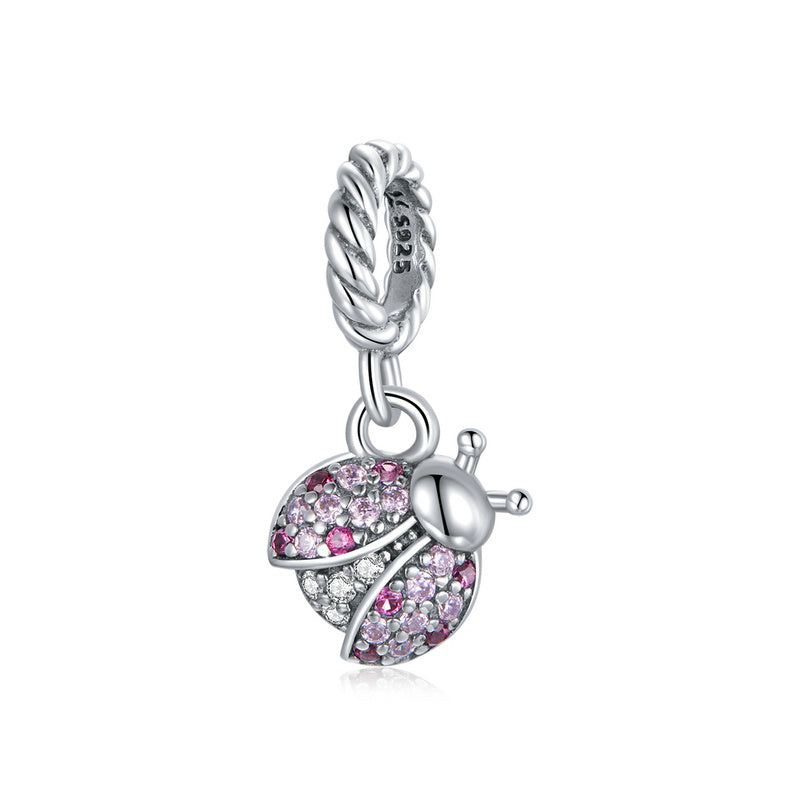 Silver charm with pink and clear gemstones on a white background