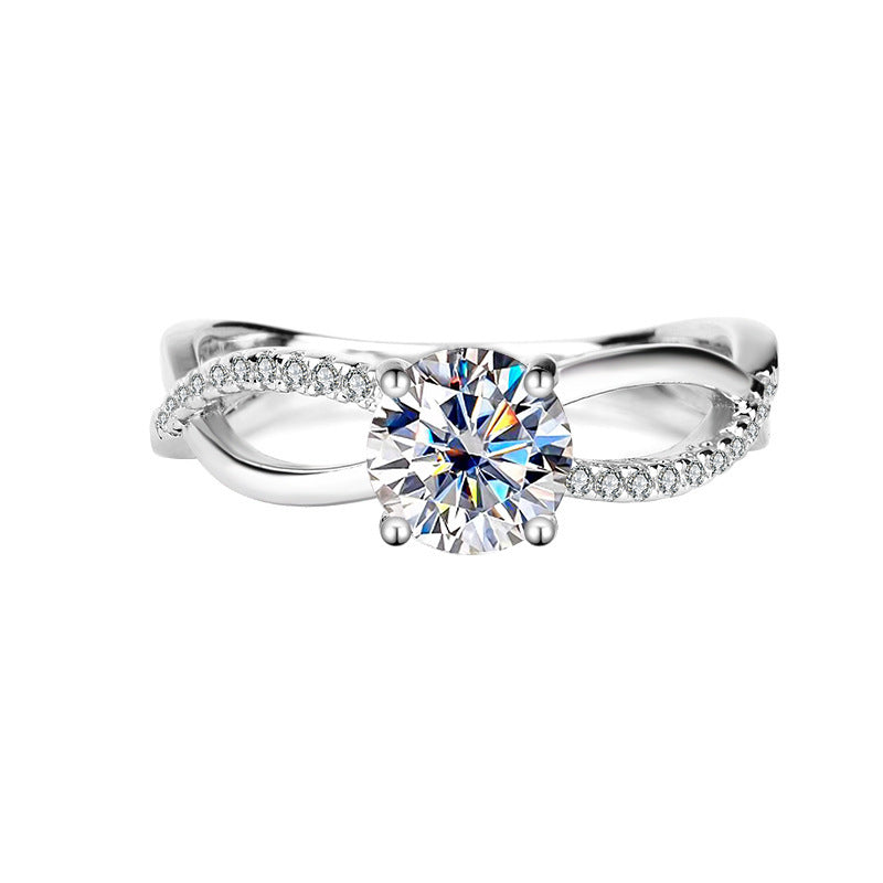Silver ring with a large diamond and smaller diamonds on the band against a white background