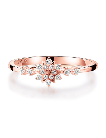 Rose gold ring with diamond snowflake design on a white background
