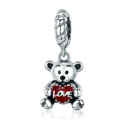 Silver charm shaped like a teddy bear holding a red heart with 'love' on a white background