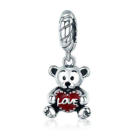 Silver charm shaped like a teddy bear holding a red heart with 'love' on a white background