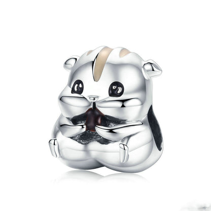 Silver charm shaped like a bear on a white background