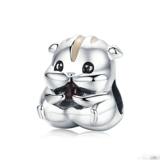Silver charm shaped like a bear on a white background