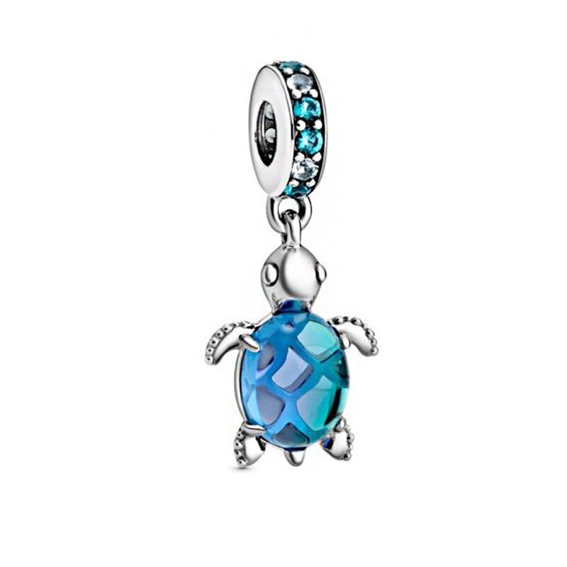 Silver turtle charm with blue gem on a white background