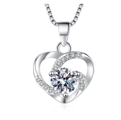 Silver heart-shaped necklace with a clear gemstone on a white background