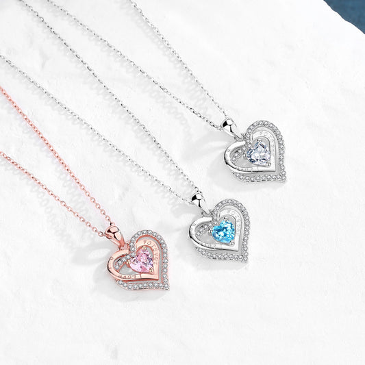 Heart-shaped pendants on necklaces with colored gemstones on a white background
