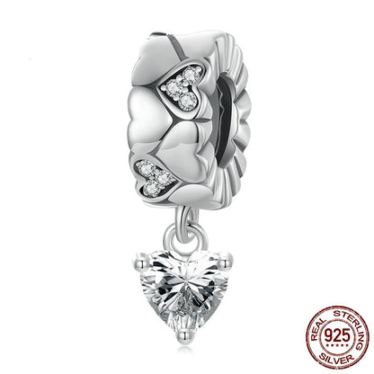 Silver charm with heart-shaped crystal on a white background