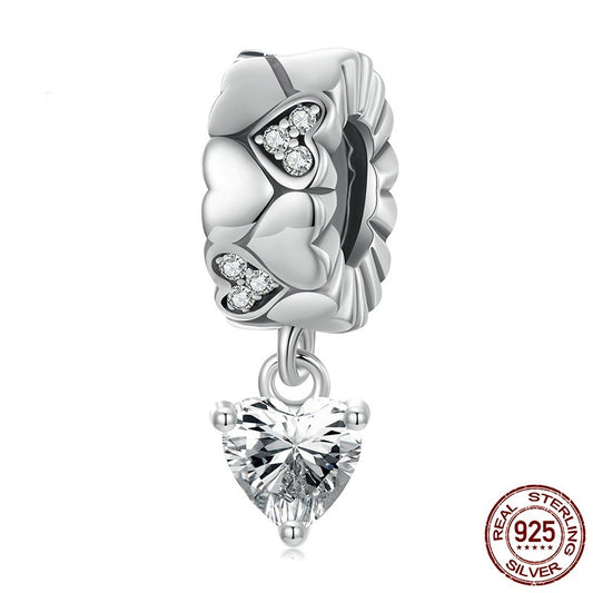 Silver charm with heart-shaped crystal on a white background