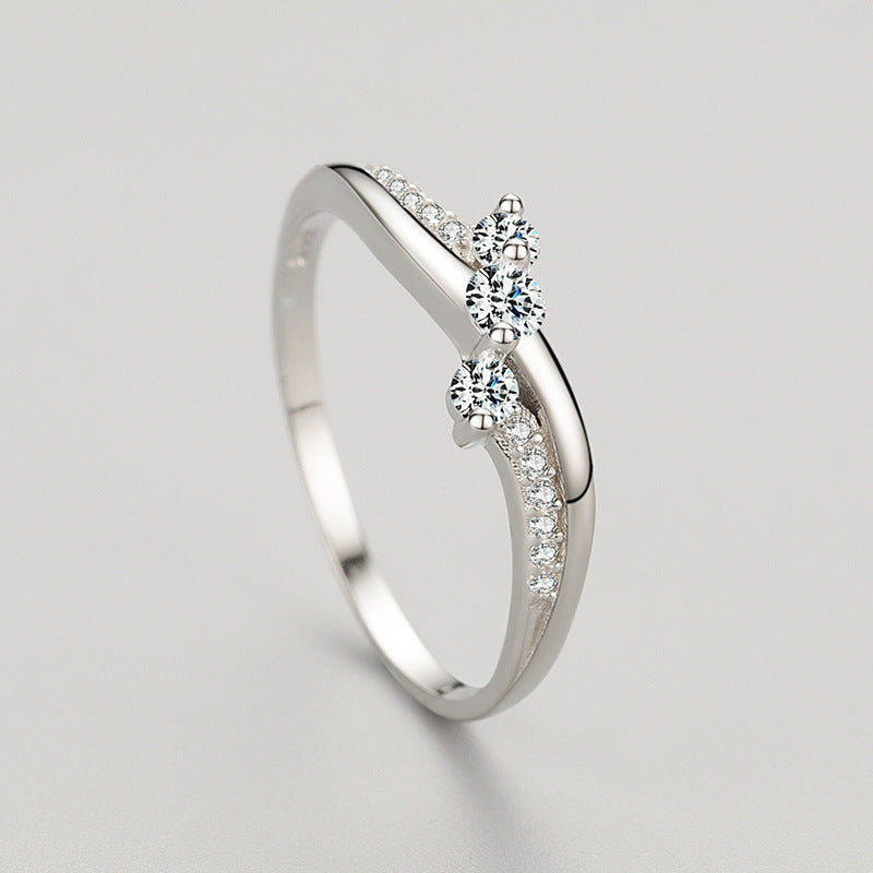 Sterling Silver ring inlayed with cubic zirconia crystals, with a twisted design on a white/grey background